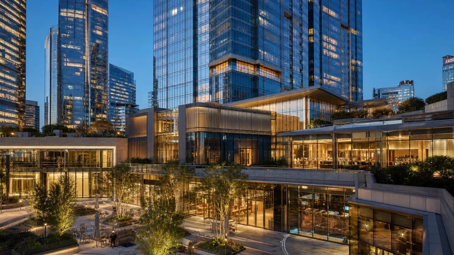 Premium mixed-use commercial real estate skyline and podium architecture at blue hour